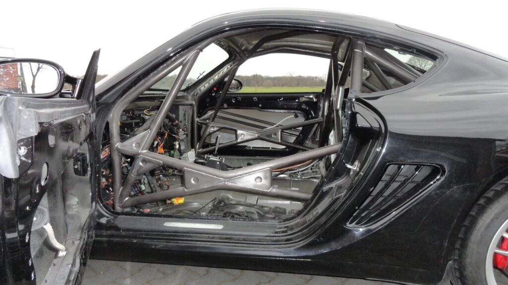 Interieur van Porsche Cayman met volledig gemonteerde rolkooi tijdens raceombouw